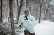 © Marko Geber - Young fit and athletic african man running and sprinting on a forest trail during winter and snow