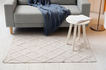 Interior of living room with stylish rug, coffee table and grey sofa