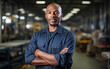 © Malchevska Studio - Black african american dark-skinned worker in a factory. Portrait of industrial worker indoors in factory. Technician with arms crossed, industrial construction industry,