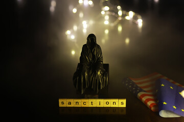 Poster - Word Sanctions made of wooden block letters with dramatic lighting and smoke