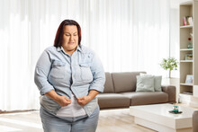 Irritated Overweight Woman At Home Trying To Button A Shirt