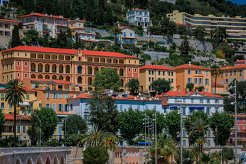 Poster - Colorful house facades above the Mediterranean Sea and beach in Old Town Vieille Ville of Menton on the French Riviera, South of France on a sunny day