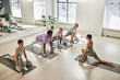 © AnnaStills - Group of people training on exercise mats together with instructor in class