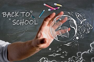 Poster - Close up of businessman hand holding abstract back to school sketch with pencils and rocket on chalkboard wall background. Education and knowledge concept.