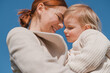 © Cavan Images - Red-haired woman tenderly hugs her little daughter, close up