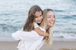© Cavan Images - Mother's love for daughter. Mother and daughter play near the sea