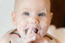 Cute Grubby Six Month Old Baby Eating Yogurt By Himself