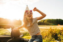 Girl Partying In A Convertible Car With A Hat And Glasses On
