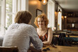 © Cavan Images - Happy young woman sitting at table with male at cafe in daylight