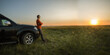 © Sergey - man standing near off-road car on vacation and  watching the sunset at nature. banner with copy space.