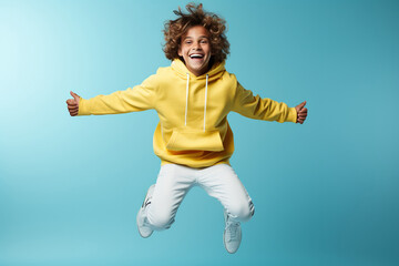 Wall Mural - Portrait of jumping teenage boy on color background.