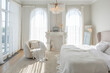 © 4595886 - cozy bright apartment with huge panoramic windows with sunlight. bedroom in white and beige tones with fireplace and soft armchair. stylish living room with log coffee table and large white sofa