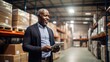 © Stavros - Warehouse accounting concept. Middle-aged African American man stands in a warehouse with a papers and checks the statements for the presence of goods.