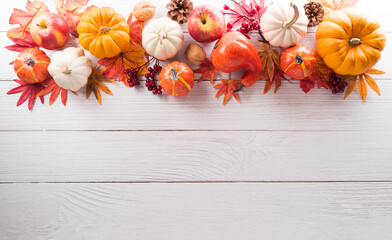 Wall Mural - thanksgiving and autumn decoration concept made from autumn leaves and pumpkin on white wooden backg