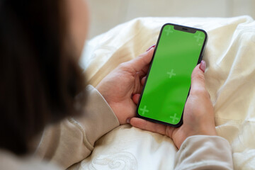 Close up Hand of teenage girl using smartphone with blank chroma key blue screen rear view