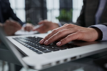 Wall Mural - man's hands typing on laptop keyboard in interior