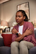 © bnenin - A pensive African-American woman sitting on the couch. looking sad.