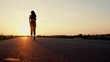 Running After Sun. Training Jogging. Beautiful Girl Doing Fitness, Jogging On Road In Sun. Jogger Girl Breathes Fresh Air In Nature. Free Young Woman Runs In Summer Park, Sunset. Jogging Outside City