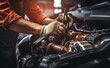 © Curioso.Photography - Hands of male auto mechanic working on car engine, repair and maintenance, workshop in the background.