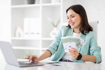 Wall Mural - Glad confident millennial european businesswoman with laptop hold lot of money cash