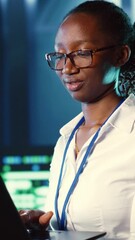 Poster - vertical video woman walking through high tech facility server rows providing computing resources fo