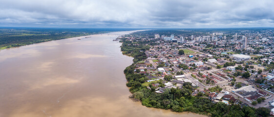 Wall Mural - Aerial drone view of Porto Velho city center skyline, streets, squares and Madeira river. Amazon rainforest in the background on cloudy summer day. Rondonia state, Brazil.