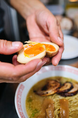 Wall Mural - Crop person adding boiled eggs to ramen