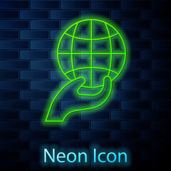 Sticker - Glowing neon line Human hand holding Earth globe icon isolated on brick wall background. Save earth concept. Vector