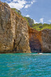 a cave on the coast of cala montgo with steep cliffs and blue sky seen from the sea