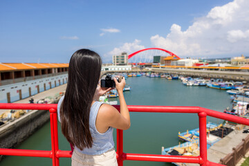 Poster - Woman use digital camera to take photo in Zhuwei Fish Harbor in Taoyuan of Taiwan