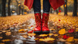 Leinwandbild Motiv Women's feet in boots on asphalt, rain, autumn leaves