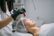 © Anna - Cosmetologist and dermatologist makes injections with a mesotherapy apparatus to a lying woman patient in a beauty salon.