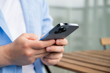 Modern technologies concept with young men using phone to send messages,surf internet,watch videos,for online shopping etc