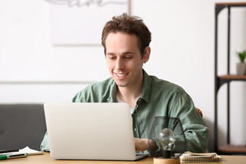 Male freelancer working with laptop at table in office