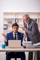 Wall Mural - Old male boss and young male employee in the office