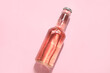 Bottle of fresh soda on pink background
