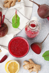 Wall Mural - Bottle and glass of fresh beetroot juice with ingredients on light background