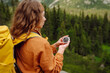 © maxbelchenko - Wanderlust concept. Stylish woman holding a compass in her hand while traveling in the mountains. The concept of hiking, nature.