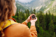 
Wanderlust Concept. Stylish Woman Holding A Compass In Her Hand While Traveling In The Mountains. The Concept Of Hiking, Nature.