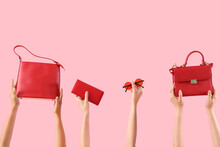 Female Hands Holding Stylish Women's Bags And Sunglasses On Pink Background