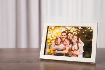 Poster - Frame with family photo on wooden table indoors, space for text