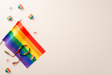 Sticker - Flat lay of celebration LGBT parade with rainbow flag, pin badges, decorative hearts and wristband with empty space for text on beige background