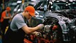© visoot - Worker attached components to an auto engine at car factory.