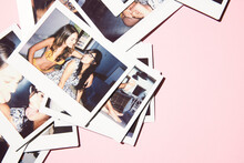 polaroids scattered on a pink background of two friends having fun