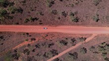 Car Driving Along A Red Dirt Road