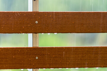 Drops of water on wooden bench after the rain, natural weather background