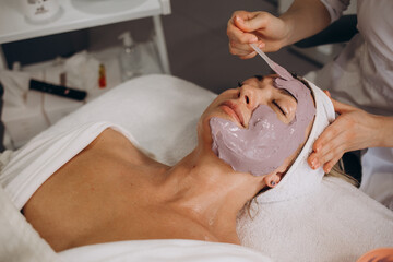 Canvas Print - Cosmetologist removes a rejuvenating mask for woman with special sponges