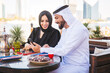 © oneinchpunch - Middle eastern couple of lovers wearing traditional emirati clothing dating outdoors in Dubai - Modern arabian couple meeting and having fun in the city