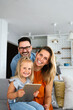 © NDABCREATIVITY - Happy family spending time at home with digital devices together. Technology people fun concept.