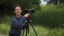 Female Photographer Out In Nature Turns And Smiles At The Camera
